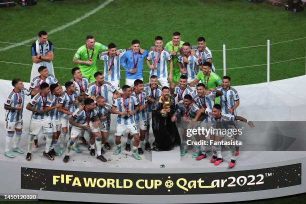 Lionel Messi of Argentina celebrates with team mates as he lifts the FIFA World Cup following the penalty shoot out victory during the FIFA World Cup...