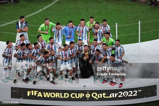 Lionel Messi of Argentina celebrates with team mates as he lifts the FIFA World Cup following the penalty shoot out victory during the FIFA World Cup...