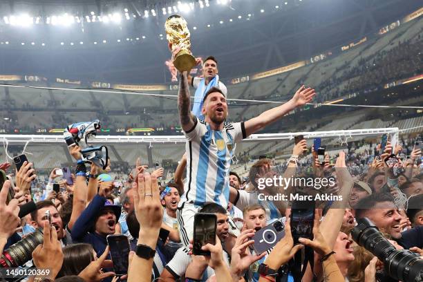 Lionel Messi of Argentina celebrates on Sergio Aguero of Argentina's shoulders with the FIFA World Cup Trophy following his team's victory in during...