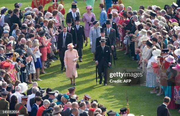 Britain's Queen Elizabeth II and Prince Philip meets guests at the first Buckingham Palace garden party of the summer in London, on May 22, 2012....