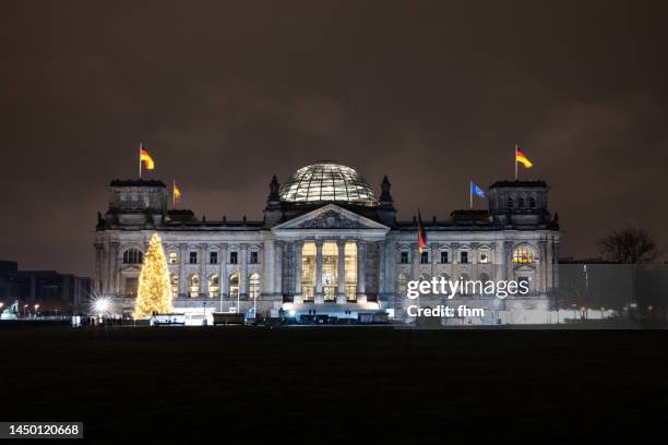 deutscher bundestag at night - reichstag building with christmas tree (german parliament building) (berlin, germany) - german flag wallpaper stock-fotos und bilder