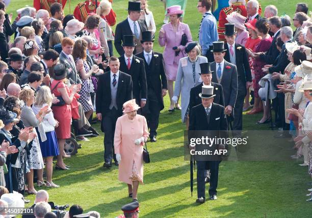 Britain's Queen Elizabeth II and Prince Philip meet guests at the first Buckingham Palace garden party of the summer in London, on May 22, 2012....