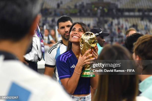 Antonela Roccuzzo, wife of Lionel Messi of Argentina celebrates with the FIFA World Cup Qatar 2022 Winner's Trophy after the team's victory during...