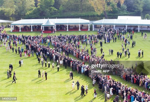 Guests wait to meet Britain's Queen Elizabeth II and Prince Philip as they host the first Buckingham Palace garden party of the summer in London, on...