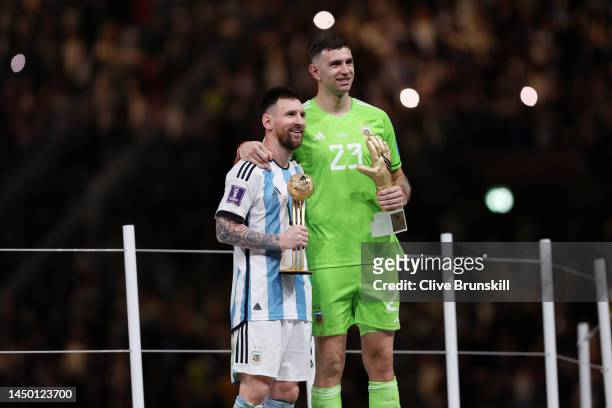 Adidas Golden Ball winner Lionel Messi and adidas Golden Glove winner Emiliano Martinez of Argentina pose at the award ceremony following the FIFA...