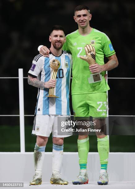 Adidas Golden Ball winner Lionel Messi and adidas Golden Glove winner Emiliano Martinez of Argentina pose at the award ceremony following the FIFA...