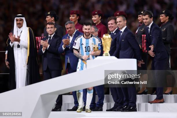 Adidas Golden Ball winner Lionel Messi of Argentina walks past the FIFA World Cup Winners The FIFA World Cup Qatar 2022 Winner's Trophy at the award...