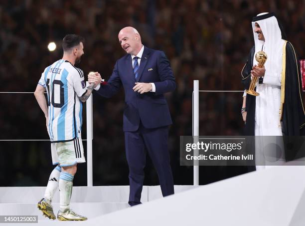 Lionel Messi of Argentina is applauded by Gianni Infantino, President of FIFA, before presented the adidas Golden Ball trophy from Sheikh Tamim bin...