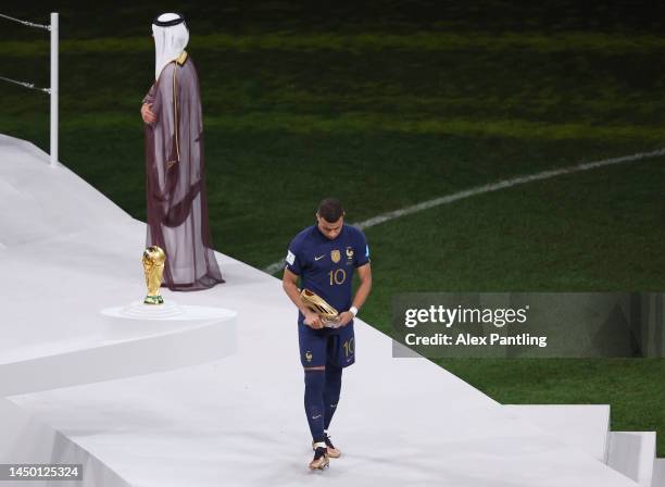 Kylian Mbappe of France looks dejected as they walk past the FIFA World Cup Qatar 2022 Winner's Trophy after presented the adidas Golden Boot award...