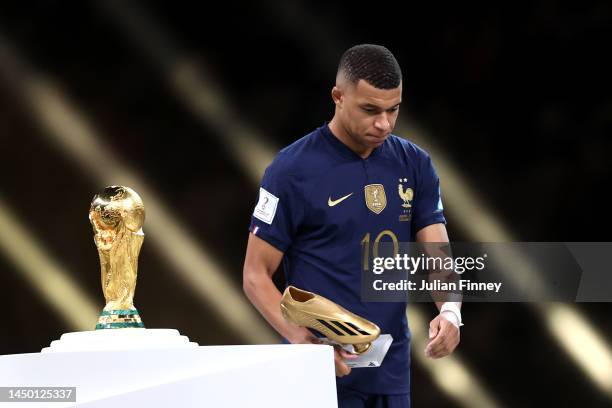 Kylian Mbappe of France looks dejected as they walk past the FIFA World Cup Qatar 2022 Winner's Trophy after presented the adidas Golden Boot award...