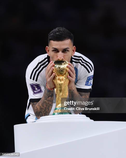 Leandro Paredes of Argentina kisses the FIFA World Cup Qatar 2022 Winner's Trophy as he walks past during the awards ceremony after the FIFA World...