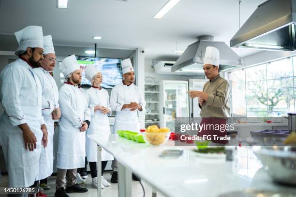 chef teaching students during cooking class - white apron stock pictures, royalty-free photos & images