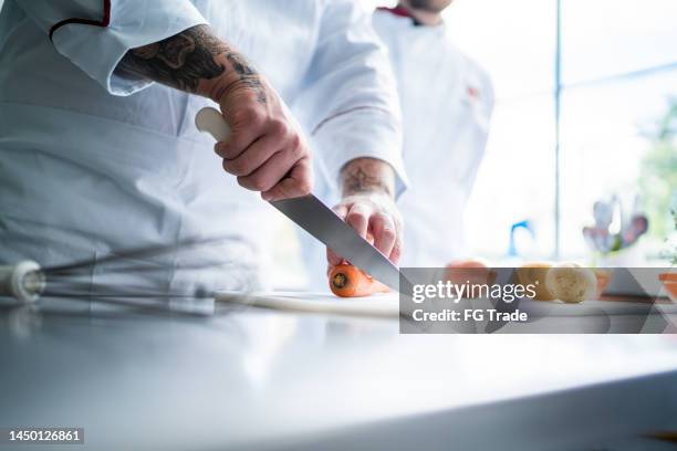 chef chopping carrots in a domestic kitchen - chopped stock pictures, royalty-free photos & images