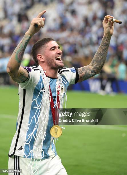 Rodrigo De Paul of Argentina cuts the net with teammates and family members after the win during the FIFA World Cup Qatar 2022 Final match between...