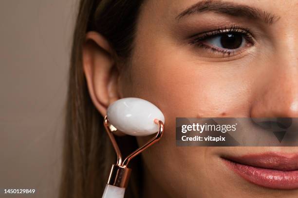 woman using a jade roller - jade close stock pictures, royalty-free photos & images