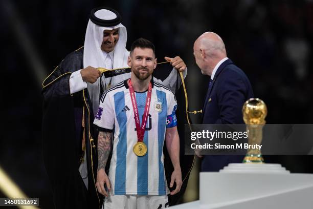 Lionel Messi of Argentina is presented a traditional robe by the Emir of Qatar, Sheik Tamim bin Hamad Al Thani, during the trophy presentation...