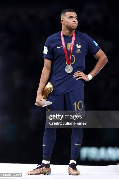 Kylian Mbappe of France reacts with his adidas Golden Boot award during the awards ceremony after the FIFA World Cup Qatar 2022 Final match between...