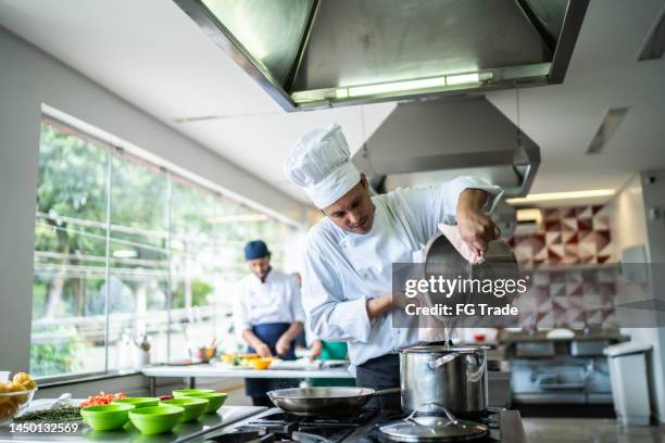 chef cooking in a commercial kitchen - chef male kitchen stock pictures, royalty-free photos & images