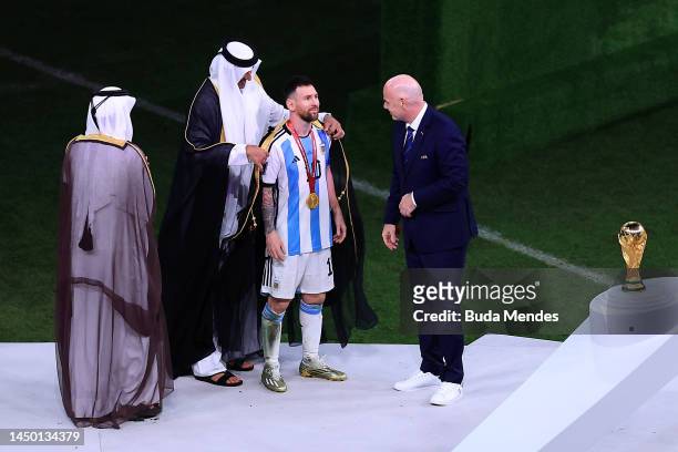 Lionel Messi of Argentina is presented a traditional robe by Sheikh Tamim bin Hamad Al Thani, Emir of Qatar, while Gianni Infantino, President of...