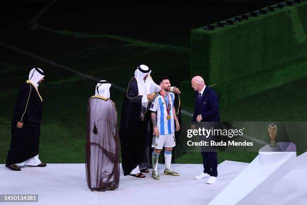 Lionel Messi of Argentina is presented a traditional robe by Sheikh Tamim bin Hamad Al Thani, Emir of Qatar, while Gianni Infantino, President of...