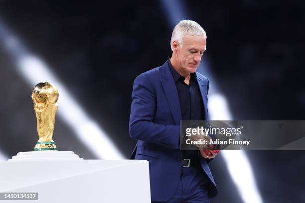 Didier Deschamps, Head Coach of France, walks past the FIFA World Cup Qatar 2022 Winner's Trophy during the award ceremony after the FIFA World Cup...