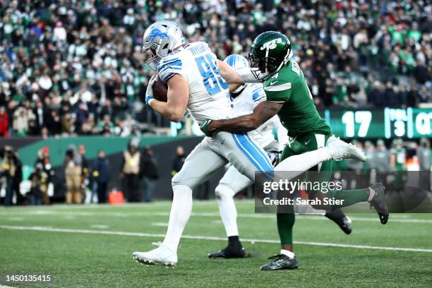 Brock Wright of the Detroit Lions scores a touchdown as D.J. Reed of the New York Jets defends during the fourth quarter at MetLife Stadium on...