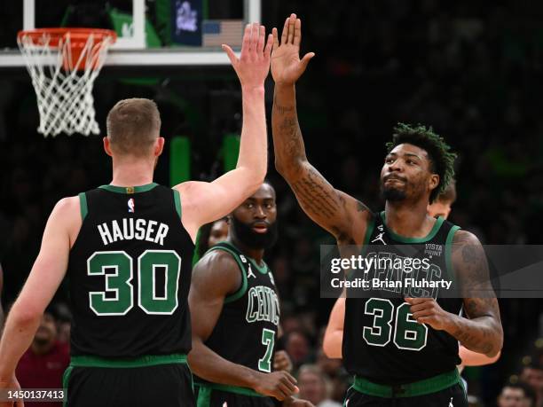 Marcus Smart of the Boston Celtics high-fives Sam Hauser after making a three-point basket against the Orlando Magic during the second quarter at the...