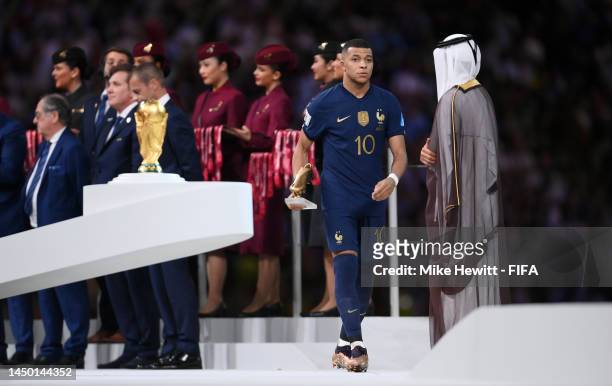 Kylian Mbappe of France looks dejected as they walk past the FIFA World Cup Qatar 2022 Winner's Trophy after presented the adidas Golden Boot award...