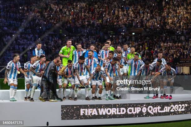 Lionel Messi of Argentina lifts the FIFA World Cup trophy alongside his teammates during the trophy presentation following the FIFA World Cup Qatar...