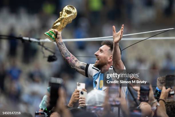Lionel Messi of Argentina lifts the FIFA World Cup trophy as he celebrates with the Argentina fans following the FIFA World Cup Qatar 2022 Final...