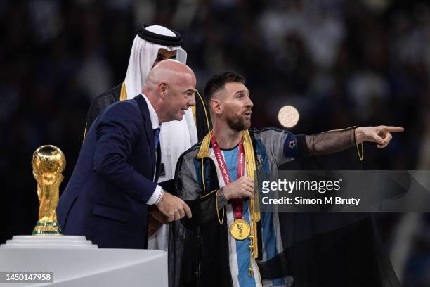 Lionel Messi of Argentina is presented a traditional robe by the Emir of Qatar, Sheik Tamim bin Hamad Al Thani, and FIFA President Gianni Infantino...
