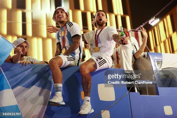 Leandro Paredes and Nicolas Otamendi of Argentina celebrate after winning the FIFA World Cup on an open top bus outside the stadium after the FIFA...