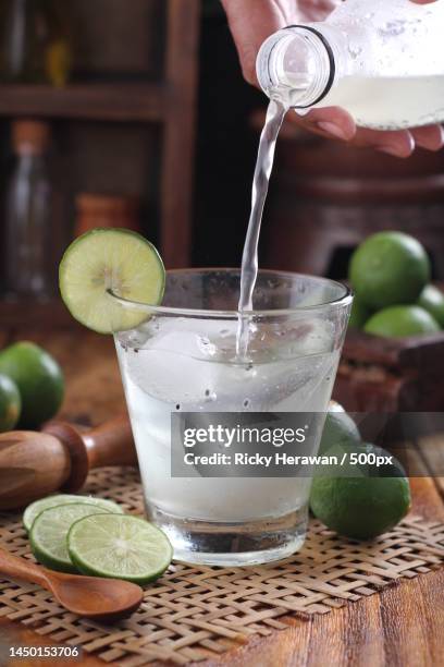 cropped hand pouring drink in glass on table,bekasi,indonesia - cachaça stock pictures, royalty-free photos & images