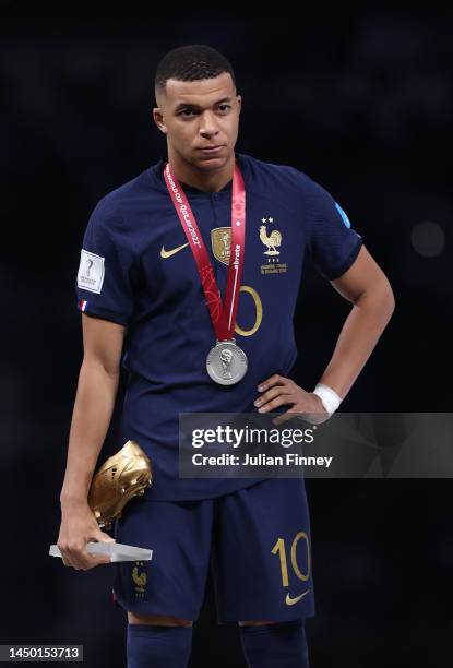 Kylian Mbappe of France reacts with his adidas Golden Boot award during the awards ceremony after the FIFA World Cup Qatar 2022 Final match between...