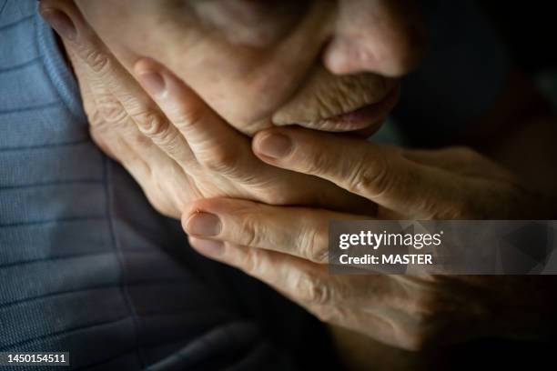 senior woman sitting alone in silence - woman head in hands sad stock pictures, royalty-free photos & images