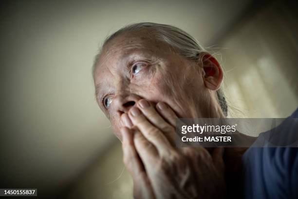 senior woman in shock after bad news - woman head in hands sad stock pictures, royalty-free photos & images