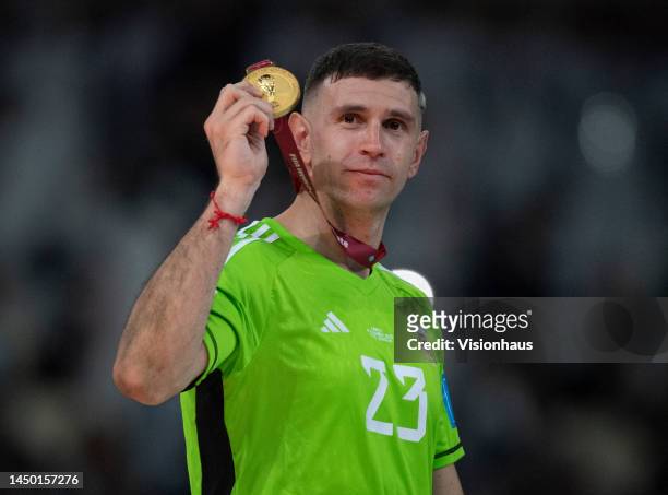 Argentina goalkeeper Emiliano Martinez celebrates with his FIFA World Cup Winner's medal following the FIFA World Cup Qatar 2022 Final match between...