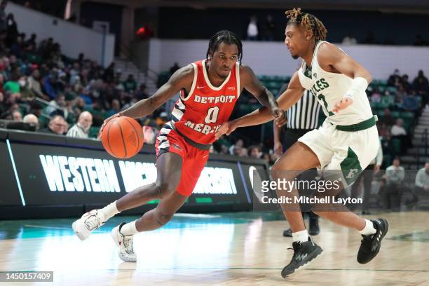 Antoine Davis of the Detroit Mercy Titans dribbles by Noah Farrakhan of the Eastern Michigan Eagles in the second half during a college basketball...