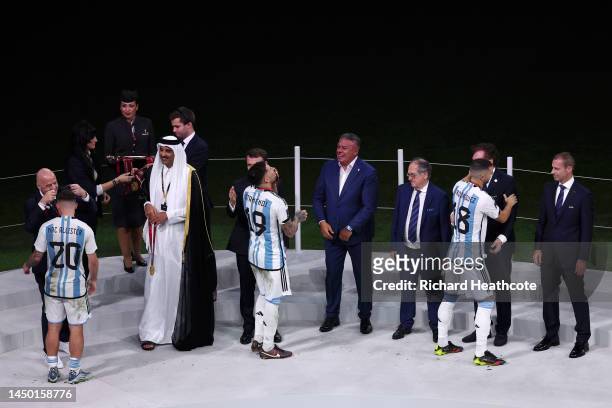 Guido Rodriguez, Nicolas Otamendi and Alexis Mac Allister of Argentina are embraced by Gianni Infantino, President of FIFA, Sheikh Tamim bin Hamad Al...
