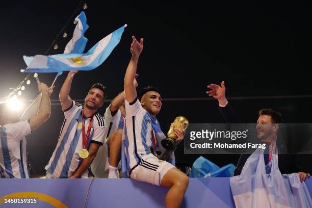 Nicolas Tagliafico and Lautaro Martinez of Argentina celebrate after winning the FIFA World Cup on an open top bus outside the stadium after the FIFA...