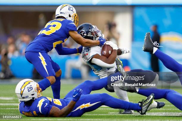 Bryce Callahan of the Los Angeles Chargers tackles Hassan Haskins of the Tennessee Titans during the second quarter of the game at SoFi Stadium on...