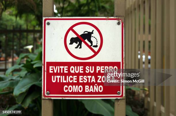 Spanishlanguage Sign In A Garden Bed Stating Evite Que Su Perro Utilice Esta Zona Como Bao Prevent Your Dog From Using This Area As A Bathroom Toilet High-Res Stock Photo