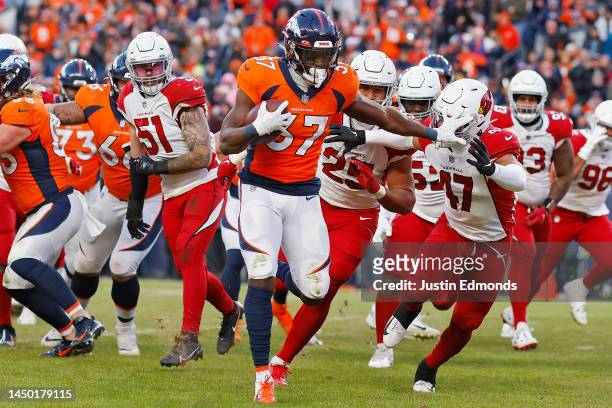 Marlon Mack of the Denver Broncos stiff arms Ezekiel Turner of the Arizona Cardinals during the third quarter at Empower Field At Mile High on...