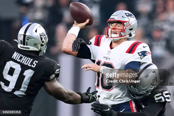 Mac Jones of the New England Patriots is pressured by Chandler Jones of the Las Vegas Raiders during the second half at Allegiant Stadium on December...