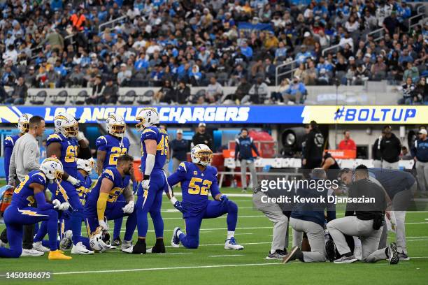 Los Angeles Chargers players take a knee as Carlo Kemp of the Los Angeles Chargers lays on the ground injured during the second half of the game...