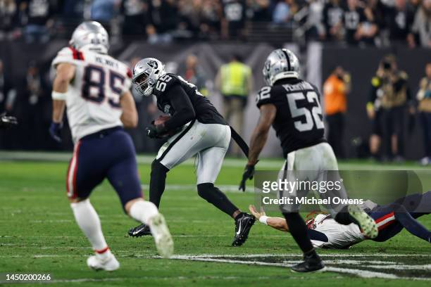 Chandler Jones of the Las Vegas Raiders intercepts a backwards pass intended for Mac Jones of the New England Patriots and runs for a touchdown to...