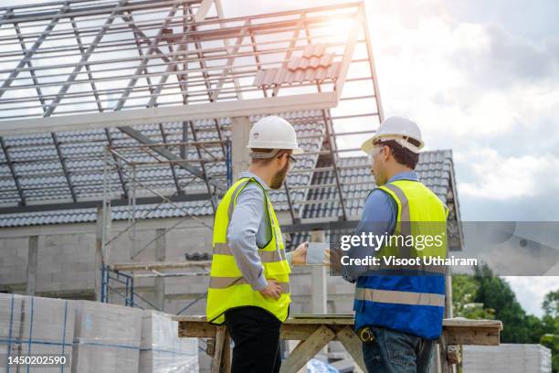 engineer analyzing blueprint at construction site,new house builder. - structural engineer stock pictures, royalty-free photos & images