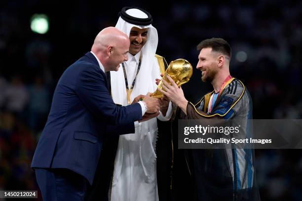 Lionel Messi of Argentina is presented with their FIFA World Cup Qatar 2022 trophy after the team's victory by Gianni Infantino, President of FIFA...