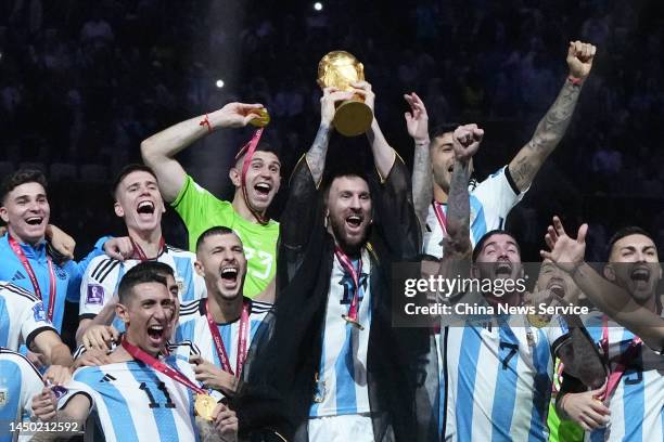 Lionel Messi of Argentina lifts the FIFA World Cup Trophy as he celebrates with team mates at the award ceremony following the FIFA World Cup Qatar...