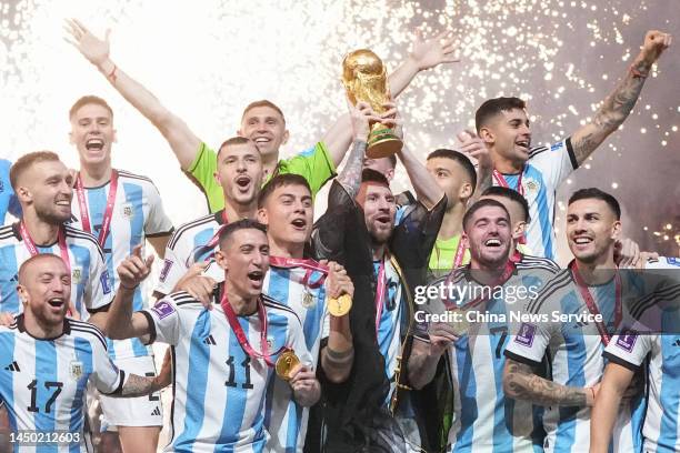 Lionel Messi of Argentina lifts the FIFA World Cup Trophy as he celebrates with team mates at the award ceremony following the FIFA World Cup Qatar...